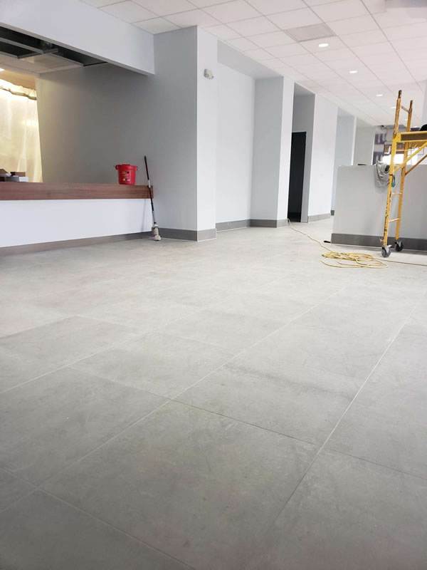 Large-format floor tile installed at an auto dealership