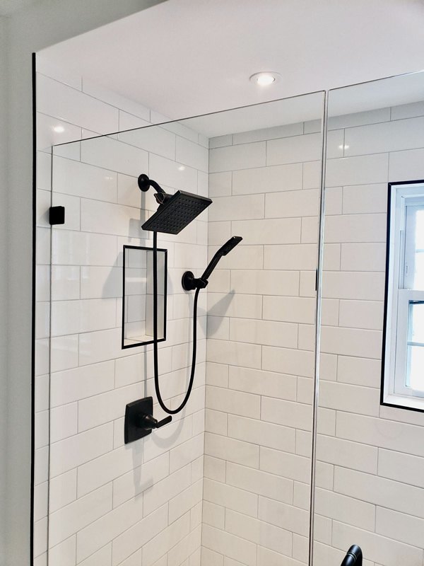 White subway tile shower with black trim